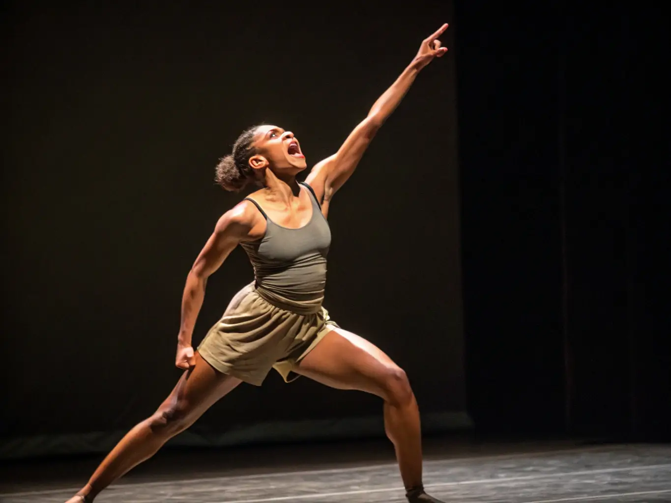 A vibrant photograph capturing a scene from a dance performance, showcasing dynamic movement and expressive lighting, set in a modern theater.